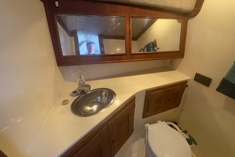 Slide: The Image of 1995 Carolina Classic 28 boat bathroom with sink, mirror, and wooden cabinets. - 41