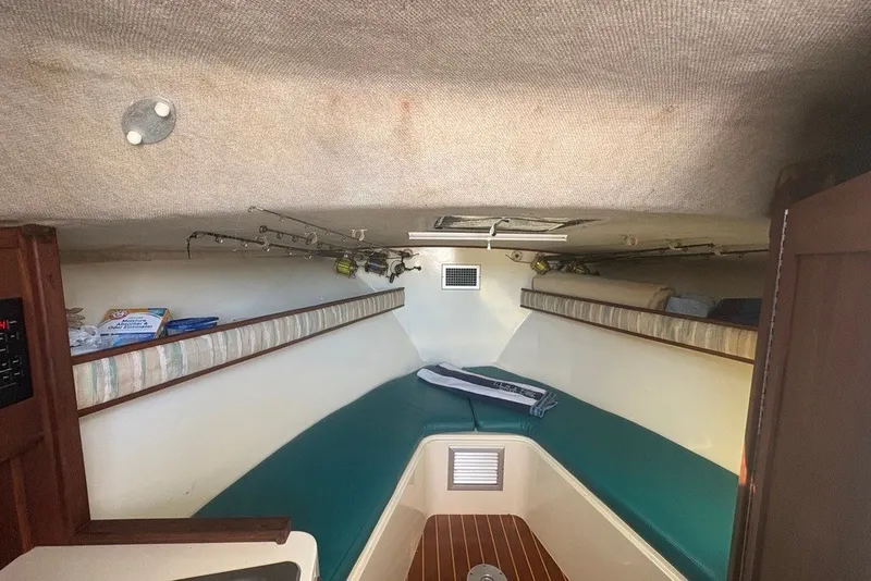 Slide: The Image of Interior cabin of a 1995 Carolina Classic 28 boat with fishing rods and seating. - 44