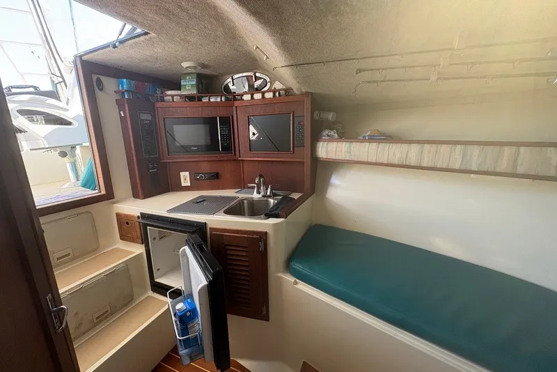 Slide: The Image of Interior of a 1995 Carolina Classic 28 boat with kitchenette and seating area. - 37