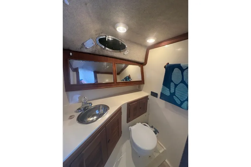 Slide: The Image of Interior of 1995 Carolina Classic 28 boat bathroom with sink, mirror, and toilet. - 42