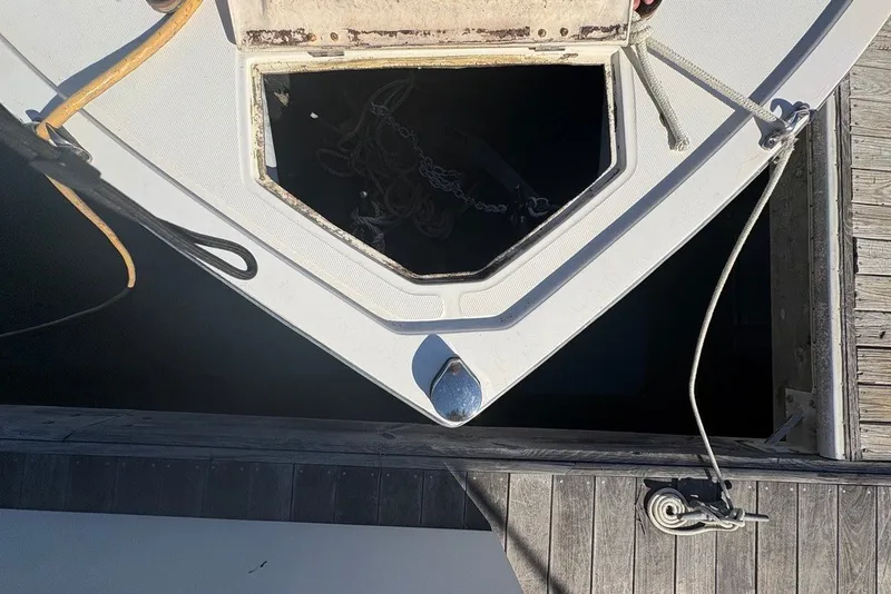 Slide: The Image of Bow of a 1995 Carolina Classic 28 boat docked, showing anchor storage. - 53