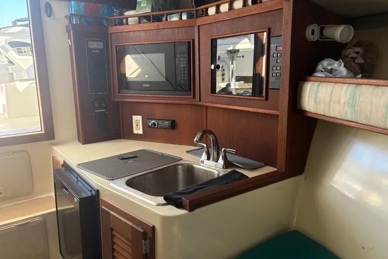 Slide: The Image of 1995 Carolina Classic 28 boat interior with kitchenette, sink, and microwave. - 40