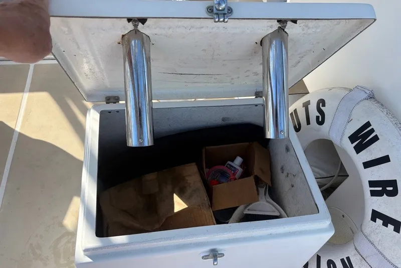 Slide: The Image of Open storage compartment on a 1995 Carolina Classic 28 boat with various items inside. - 27