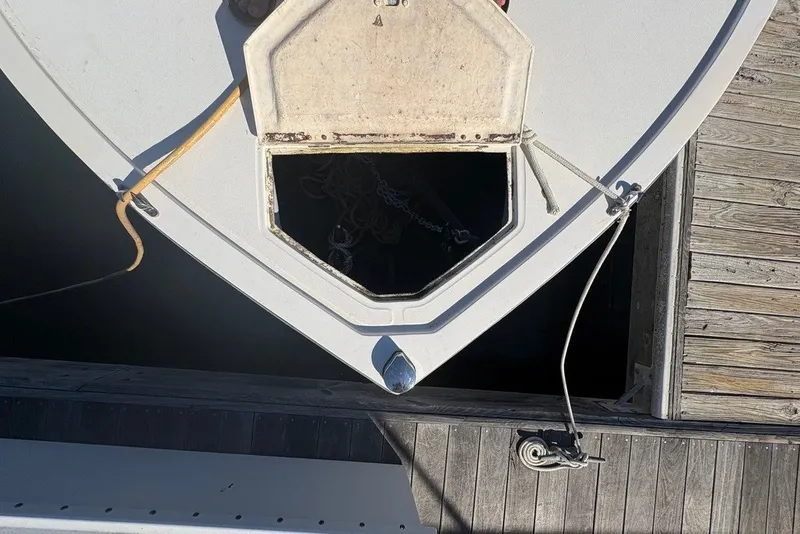 Slide: The Image of Bow of a 1995 Carolina Classic 28 boat docked, showing anchor hatch and ropes. - 54