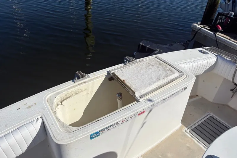 Slide: The Image of 1995 Carolina Classic 28 boat with open storage compartment by the water. - 31
