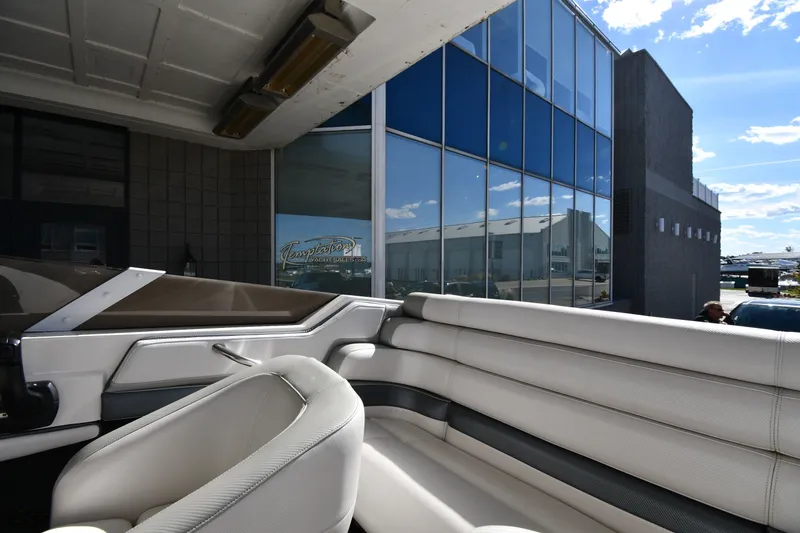 Slide: The Image of Interior of a 1995 Fountain 24 Competition boat with white seating, near a modern glass building. - 22