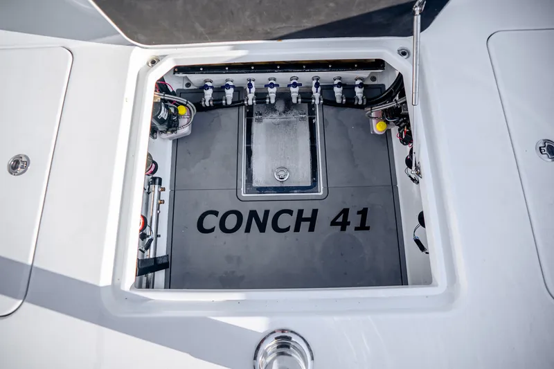 Slide: The Image of 2024 Conch 41 boat compartment with visible wiring and labeled interior. - 22