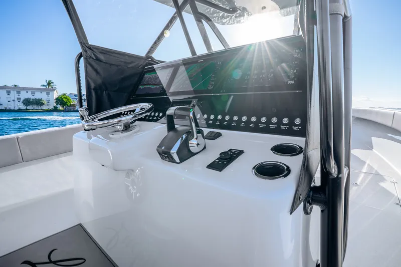 Slide: The Image of 2024 Conch 41 boat dashboard with steering wheel and control panel, sunlight reflecting. - 25