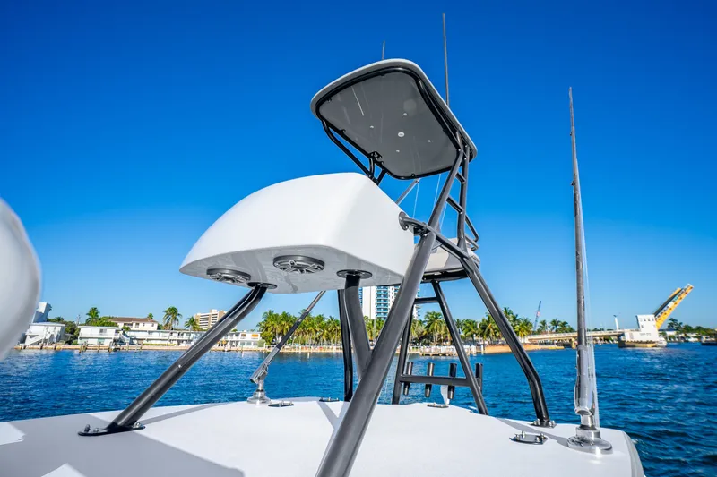 Slide: The Image of 2024 Conch 41 boat with tower against clear blue sky and waterfront backdrop. - 34