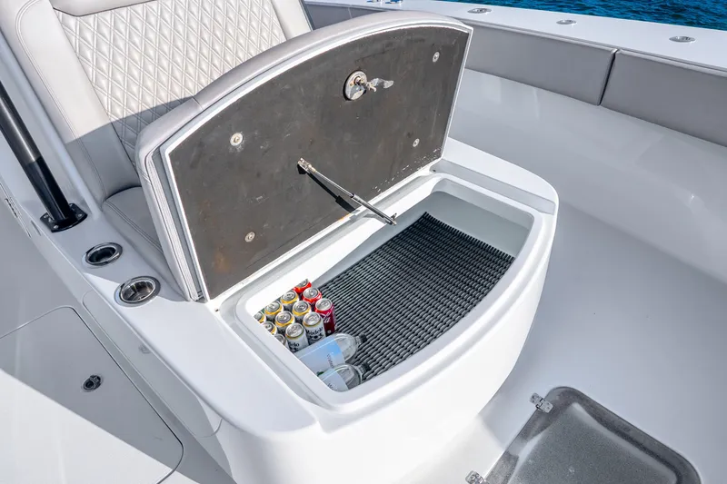 Slide: The Image of 2024 Conch 41 boat cooler with drinks, open lid, and cushioned seating. - 42