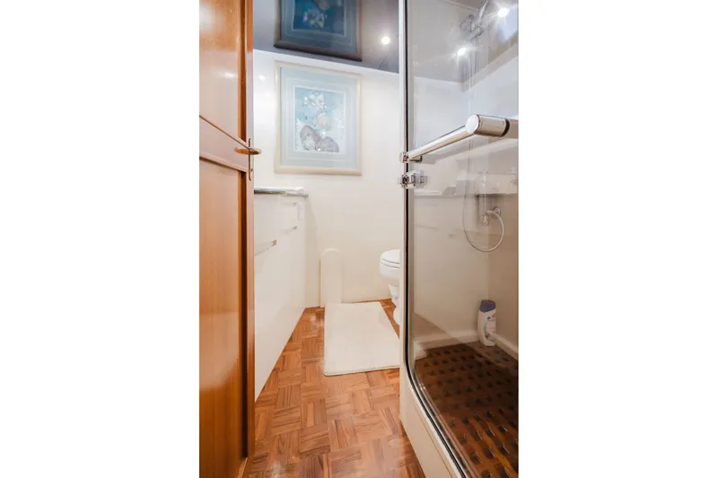 Slide: The Image of Bathroom interior of 1999 Ocean Alexander 680 Classicco yacht, featuring wood flooring and glass shower. - 79