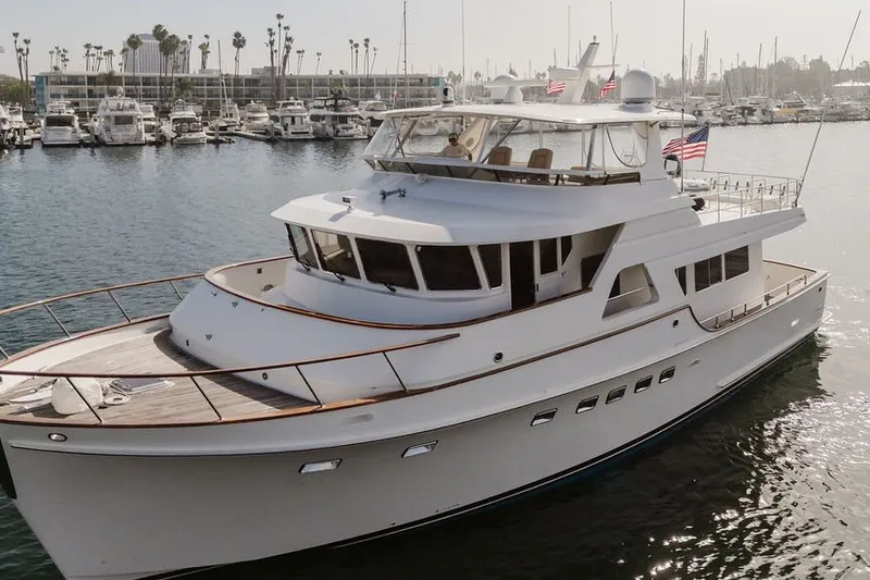 Slide: The Image of 1999 Ocean Alexander 680 Classicco yacht docked in a marina, surrounded by other boats. - 124