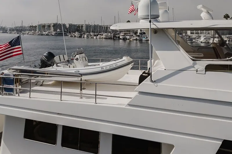 Slide: The Image of Ocean Alexander 680 Classicco yacht, 1999 model, docked with American flag and tender boat. - 112