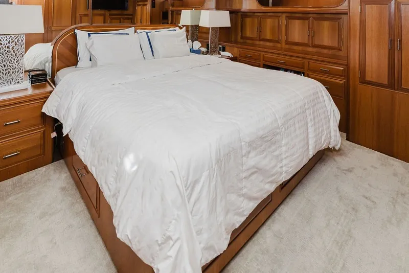 Slide: The Image of Luxurious bedroom interior on 1999 Ocean Alexander 680 Classicco yacht, featuring elegant wood cabinetry. - 58