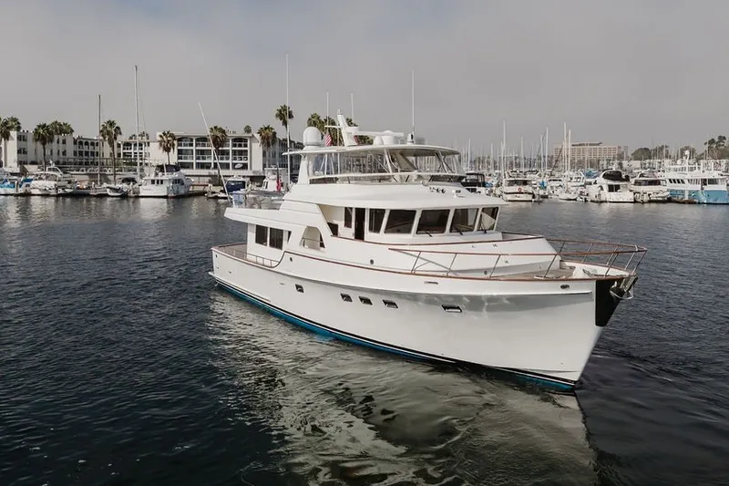 Slide: The Image of 1999 Ocean Alexander 680 Classicco yacht docked in a marina, surrounded by other boats. - 113