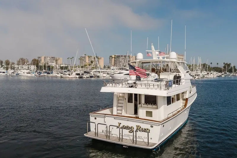 Slide: The Image of Ocean Alexander 680 Classicco yacht, 1999 model, cruising in a marina with cityscape background. - 115