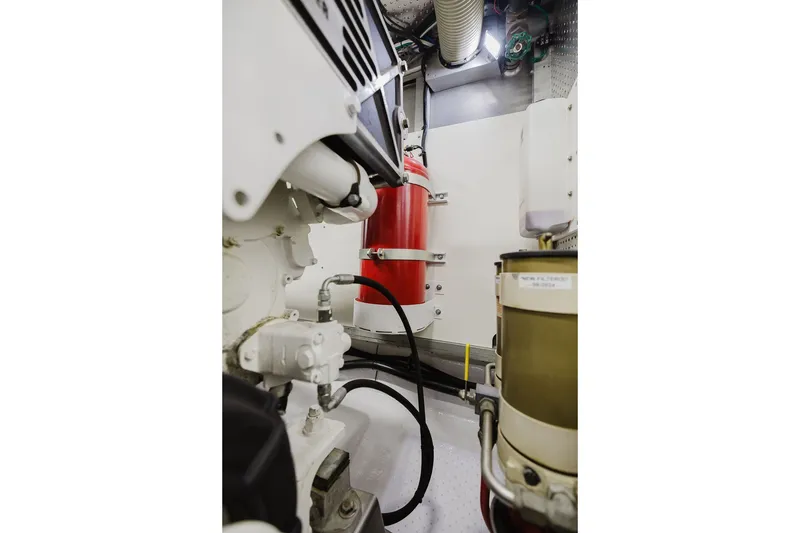 Slide: The Image of Engine room of 1999 Ocean Alexander 680 Classicco yacht, featuring machinery and fire extinguisher. - 93
