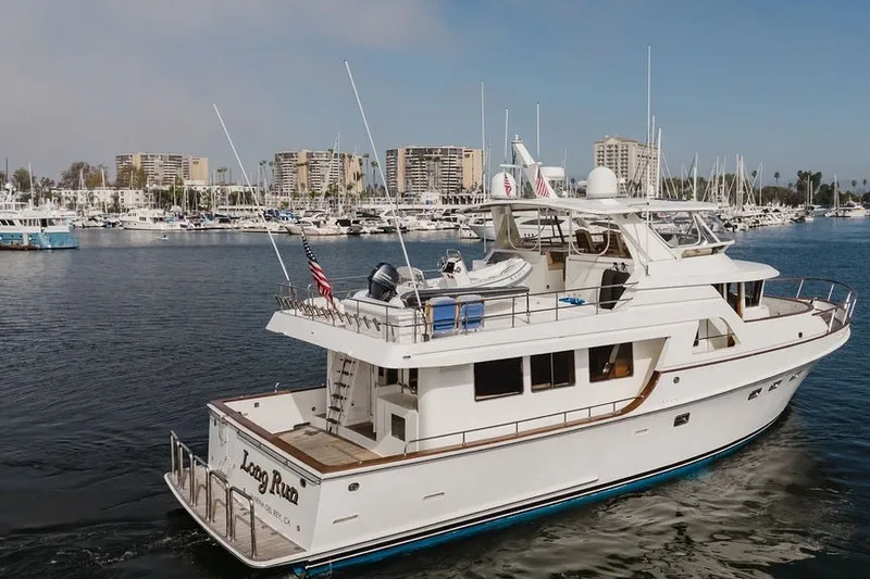 Slide: The Image of Ocean Alexander 680 Classicco yacht, 1999 model, cruising in a marina with cityscape background. - 114