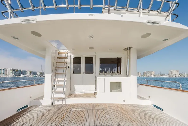 Slide: The Image of 1999 Ocean Alexander 680 Classicco yacht deck with ladder, overlooking marina and cityscape. - 14