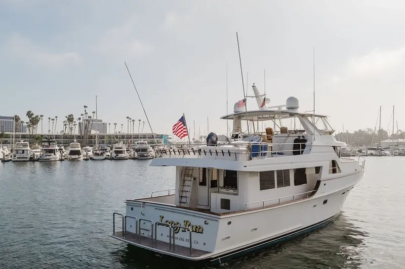 Slide: The Image of 1999 Ocean Alexander 680 Classicco yacht docked in marina, American flag displayed. - 120