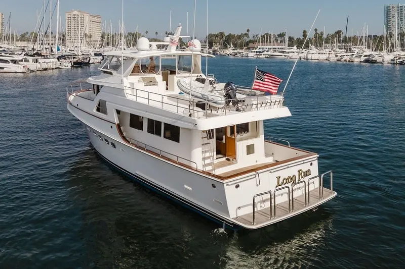 Slide: The Image of 1999 Ocean Alexander 680 Classicco yacht docked in a marina, displaying an American flag. - 122