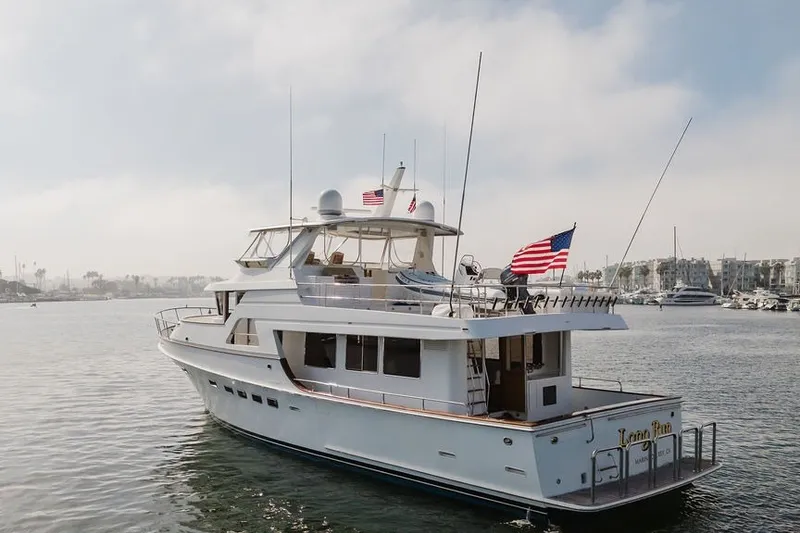 Slide: The Image of 1999 Ocean Alexander 680 Classicco yacht on calm waters, displaying American flags. - 121