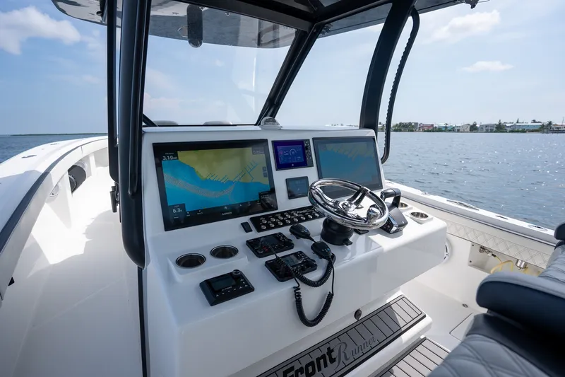 Slide: The Image of 2023 Front Runner 39 Center Console boat dashboard with navigation screens on open water. - 12