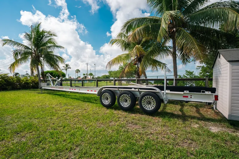 Slide: The Image of Trailer for 2023 Front Runner 39 Center Console, parked on grass with palm trees. - 84