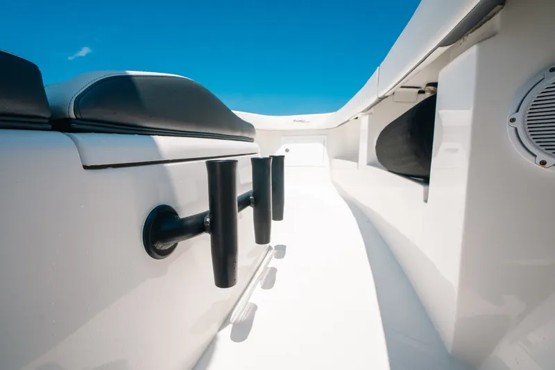 Slide: The Image of 2023 Front Runner 39 Center Console boat interior with rod holders and seating under clear blue sky. - 76