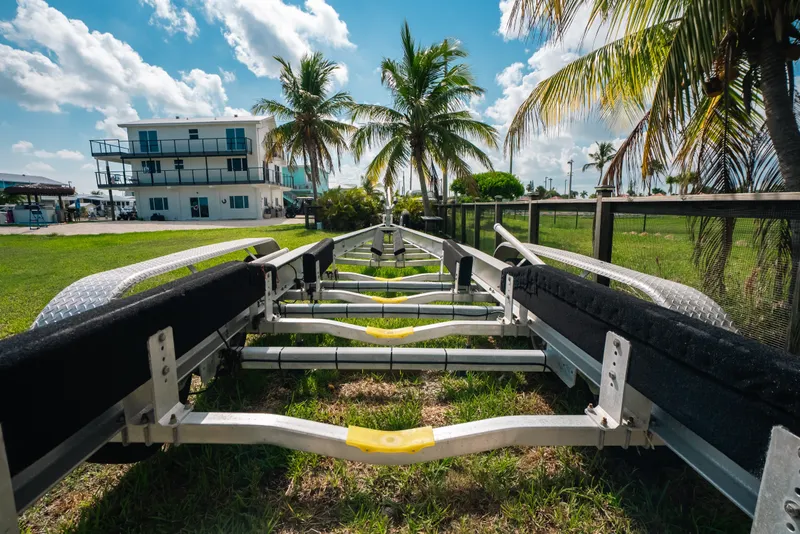 Slide: The Image of Boat trailer for 2023 Front Runner 39 Center Console, with palm trees and house in background. - 85