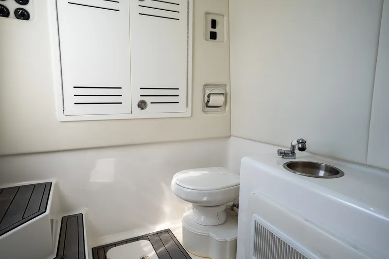 Slide: The Image of 2023 Front Runner 39 Center Console boat bathroom with toilet, sink, and storage cabinets. - 45
