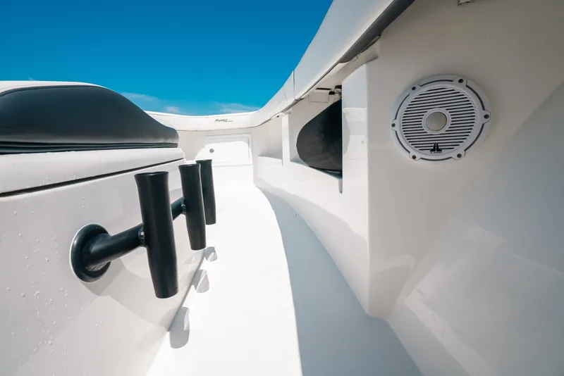 Slide: The Image of 2023 Front Runner 39 Center Console boat interior with rod holders and speaker, under clear blue sky. - 77