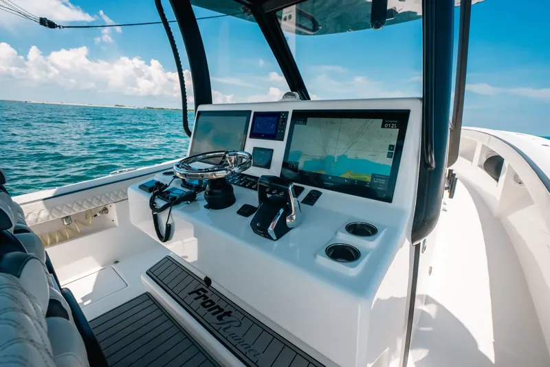 Slide: The Image of 2023 Front Runner 39 Center Console boat dashboard with navigation screens and steering wheel. - 61