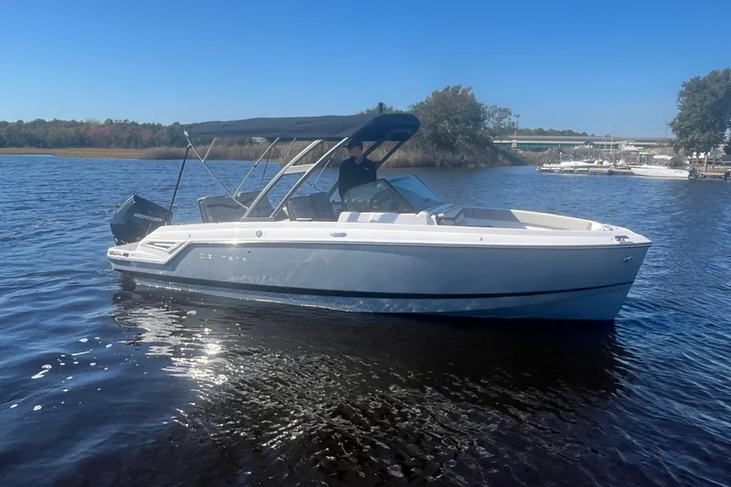 The Image of 2027 Monterey Elite 23 OB boat on calm water, featuring sleek design and modern outboard motor. - 0