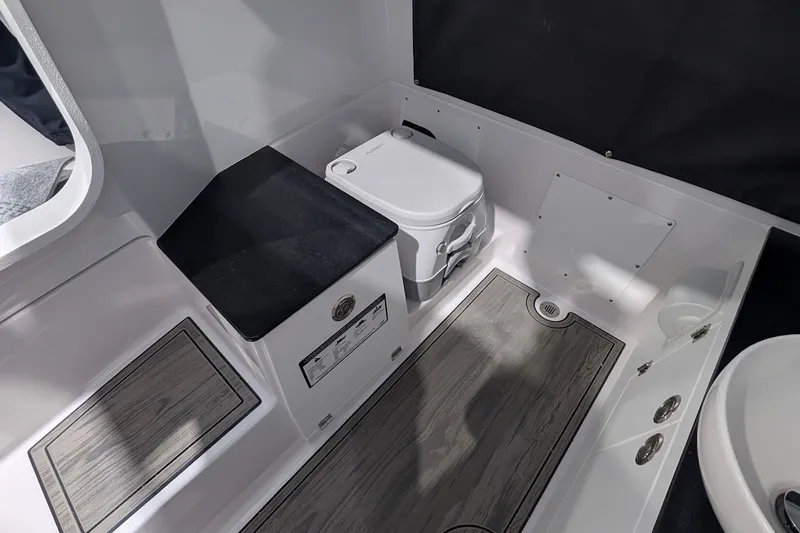 Slide: The Image of Interior of 2027 Monterey Elite 23 OB boat featuring a compact marine toilet. - 19
