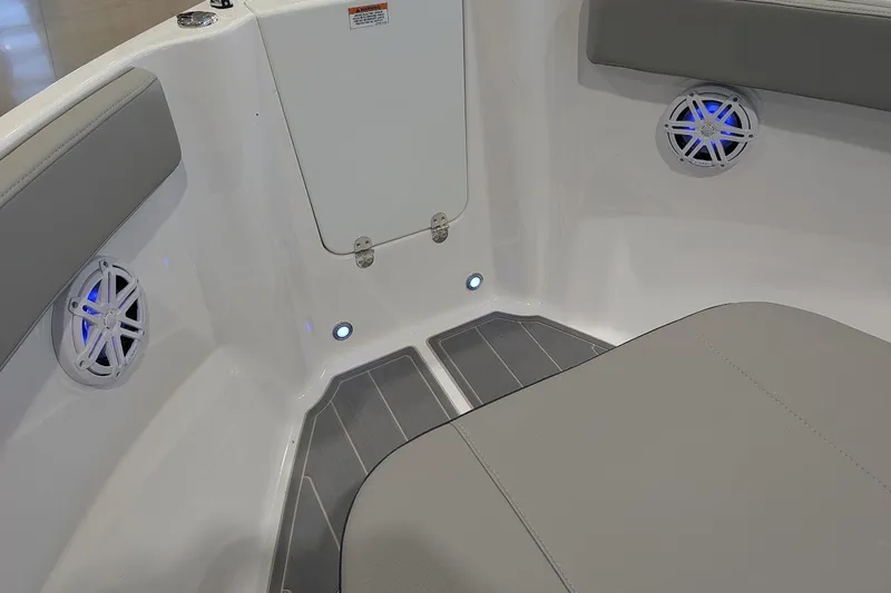 Slide: The Image of Interior of 2027 Monterey Elite 23 OB boat with gray seating and blue-lit speakers. - 21