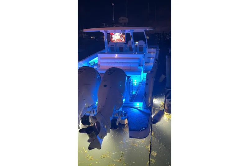 Slide: The Image of 2020 Regal 38 SAV boat with illuminated deck and powerful engines at night. - 54