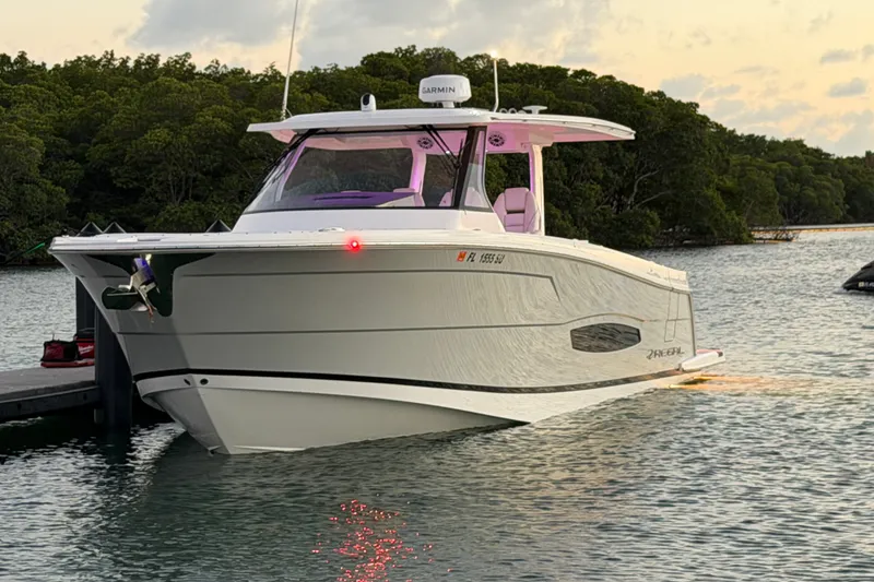 Slide: The Image of 2020 Regal 38 SAV boat docked on calm water at sunset. - 20