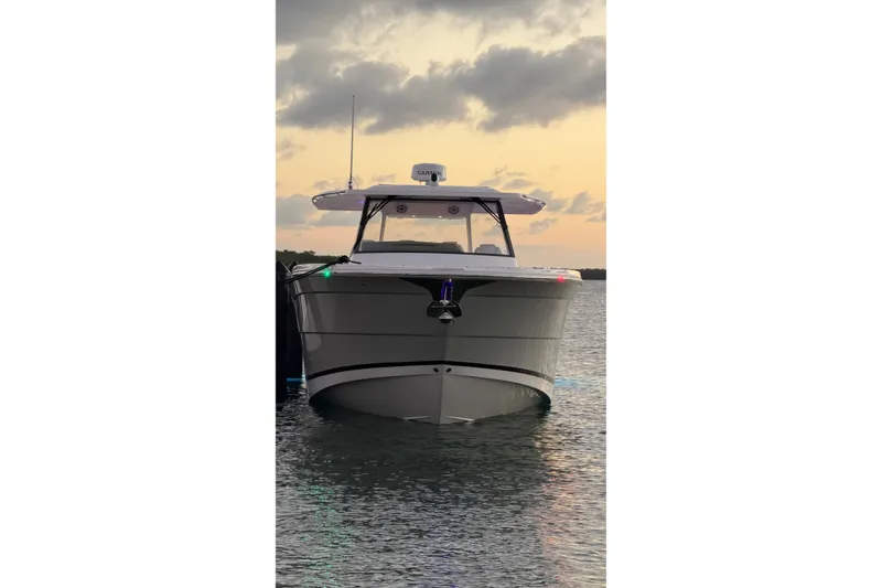 Slide: The Image of 2020 Regal 38 SAV boat on water at sunset, front view. - 14