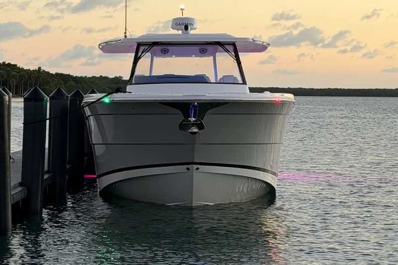 Slide: The Image of 2020 Regal 38 SAV boat docked at sunset, featuring sleek design and modern technology. - 16