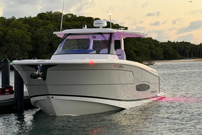 Slide: The Image of 2020 Regal 38 SAV boat docked at sunset with LED lights. - 2