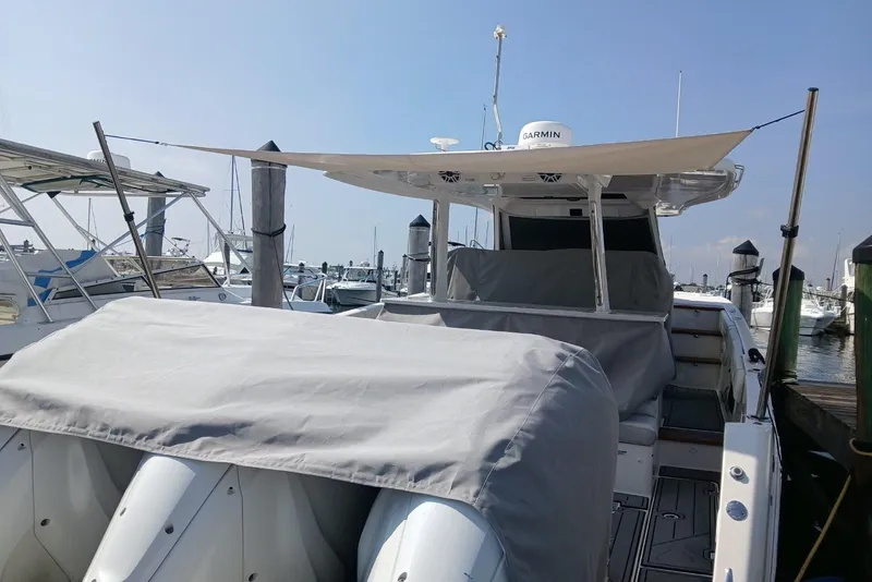 Slide: The Image of 2020 Regal 38 SAV boat docked, covered with protective tarps, and equipped with Garmin technology. - 13