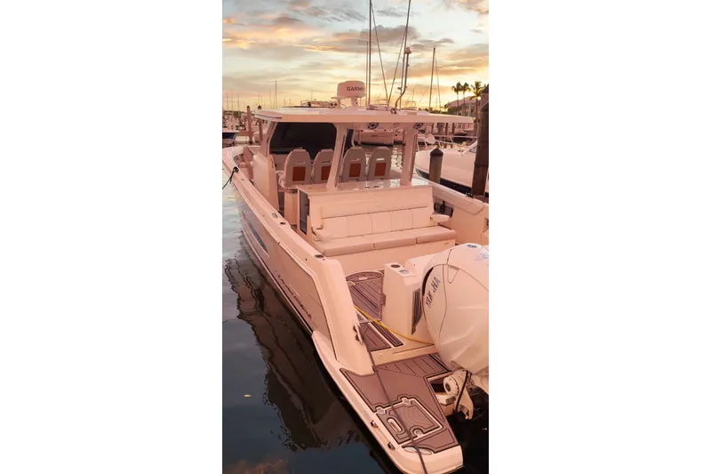 Slide: The Image of 2020 Regal 38 SAV boat docked at sunset, showcasing sleek design and spacious seating. - 29