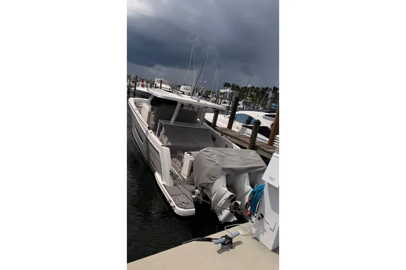 Slide: The Image of 2020 Regal 38 SAV boat docked at marina under cloudy sky. - 12