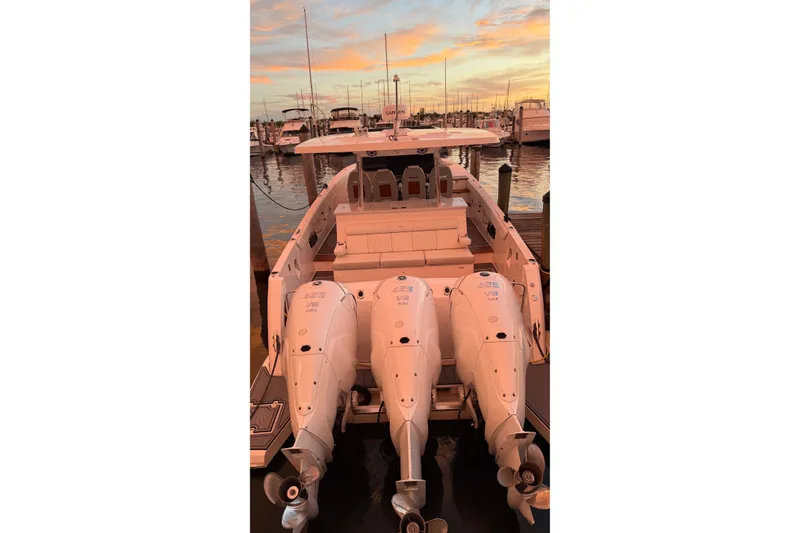 Slide: The Image of 2020 Regal 38 SAV boat with triple outboard engines at sunset marina. - 25