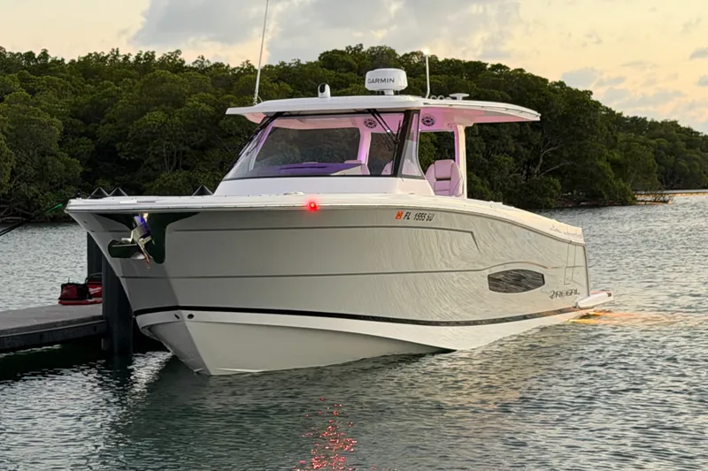 Slide: The Image of 2020 Regal 38 SAV boat docked on calm water at sunset. - 19