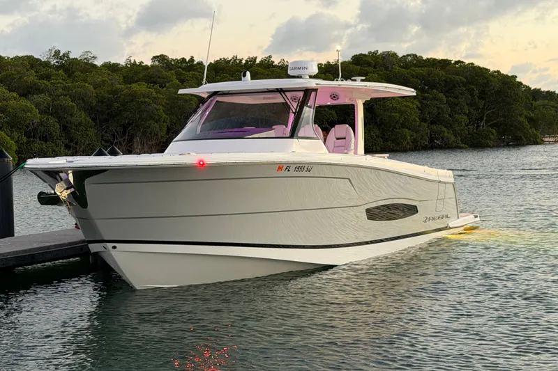 Slide: The Image of 2020 Regal 38 SAV boat docked on calm water at sunset. - 21