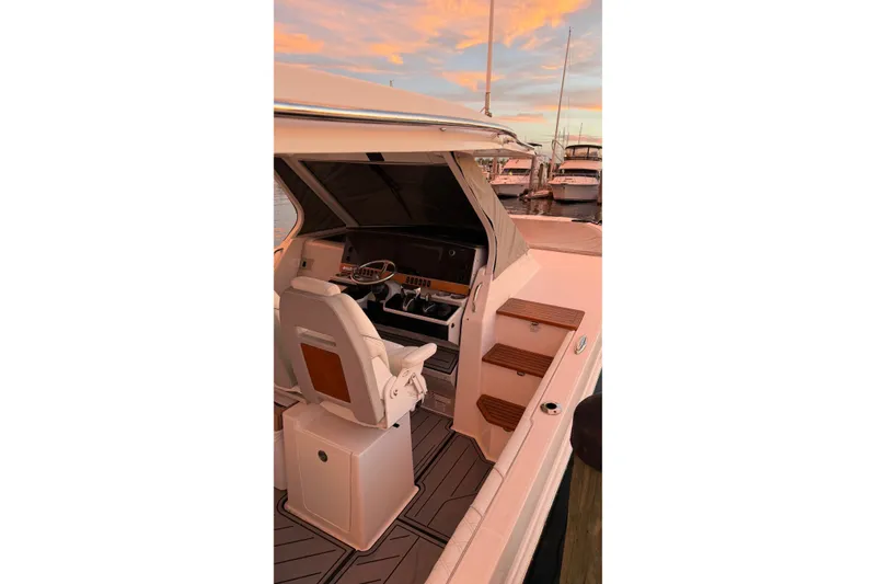 Slide: The Image of 2020 Regal 38 SAV boat interior with helm, steps, and sunset view. - 23