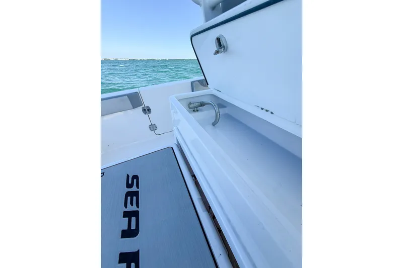 Slide: The Image of 2023 Sea Pro 320 DLX Offshore boat deck with storage and ocean view. - 30