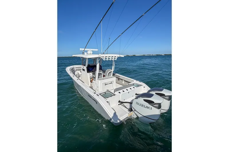 Slide: The Image of 2023 Sea Pro 320 DLX Offshore boat with dual Suzuki engines on open water. - 12